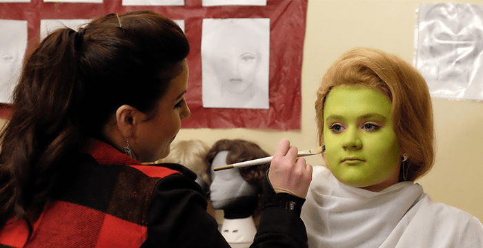 high school student in costume makeup during theater arts workshop