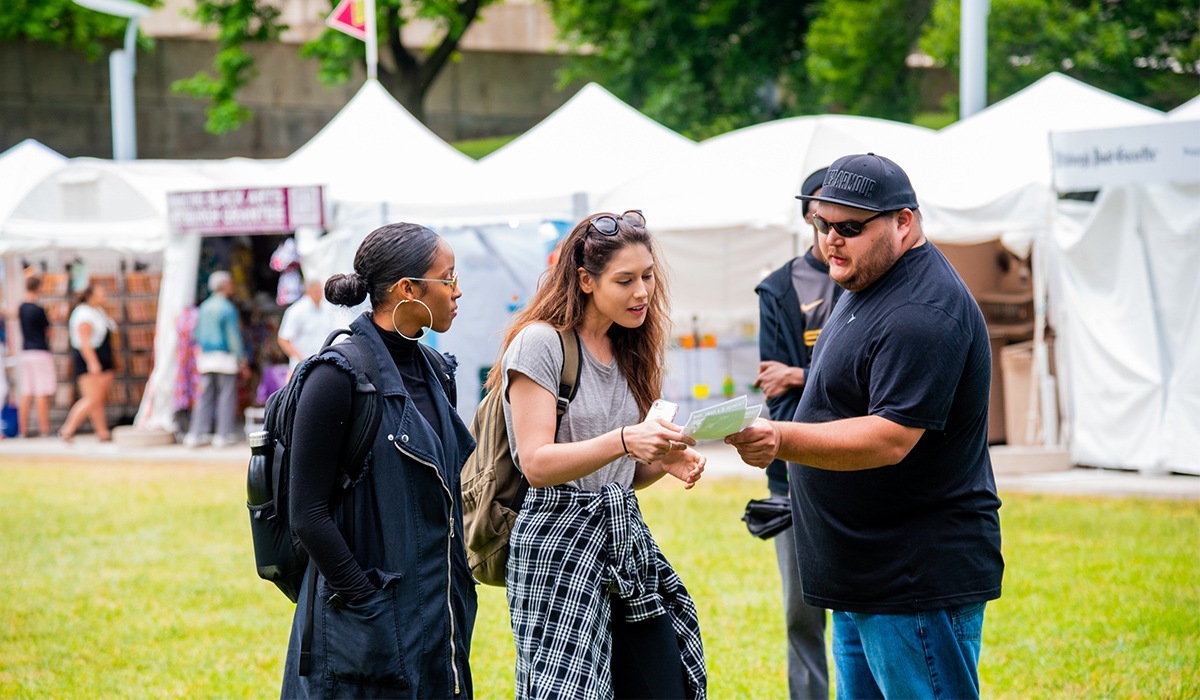 Festival goers looking at guide for the Dollar Bank Three Rivers Arts Festival