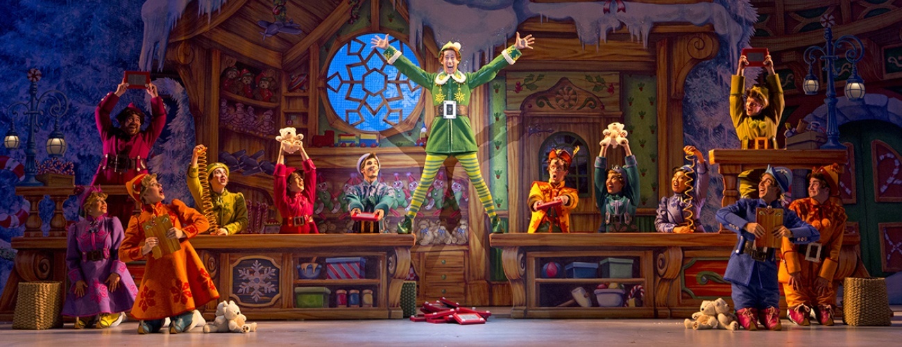 Buddy the Elf standing on a table in Christmastown