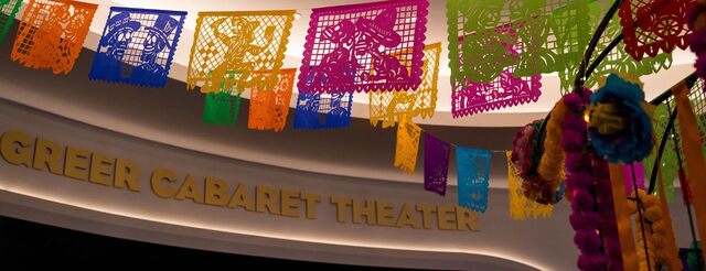 Multi-colored paper squares with intricate designs hang from the ceiling.