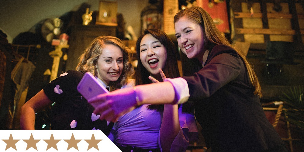 three friends take a selfie inside liberty magic's theater entrance