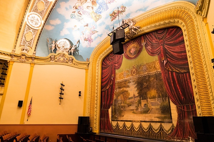 a photo of the front of the byham theater auditorium, including the lowered fire curtain on the left of the frame