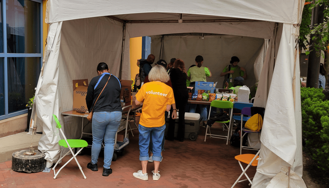 Ginny faces away from the camera, wearing an orange volunteer t-shirt.
