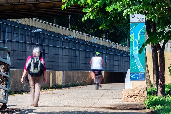 A walker and a biker share the path