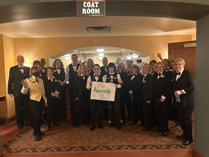 A group of volunteers hold up a sign that says We Apprecite You!