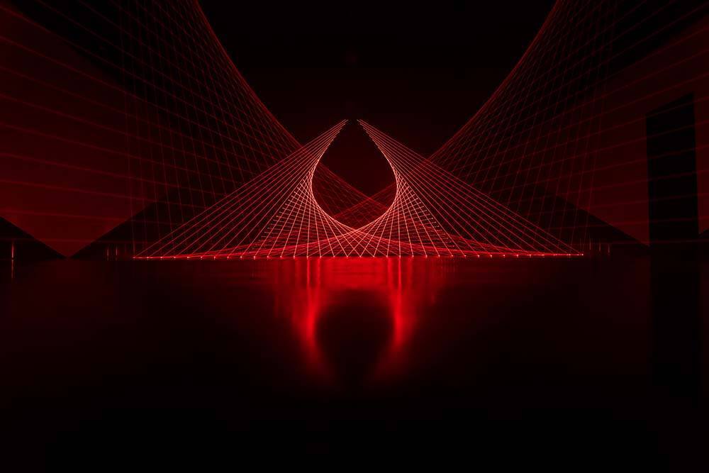  A wide view of Double Gemini, where dozens of red lasers in a dark room form a geometric pattern of curves and grids
