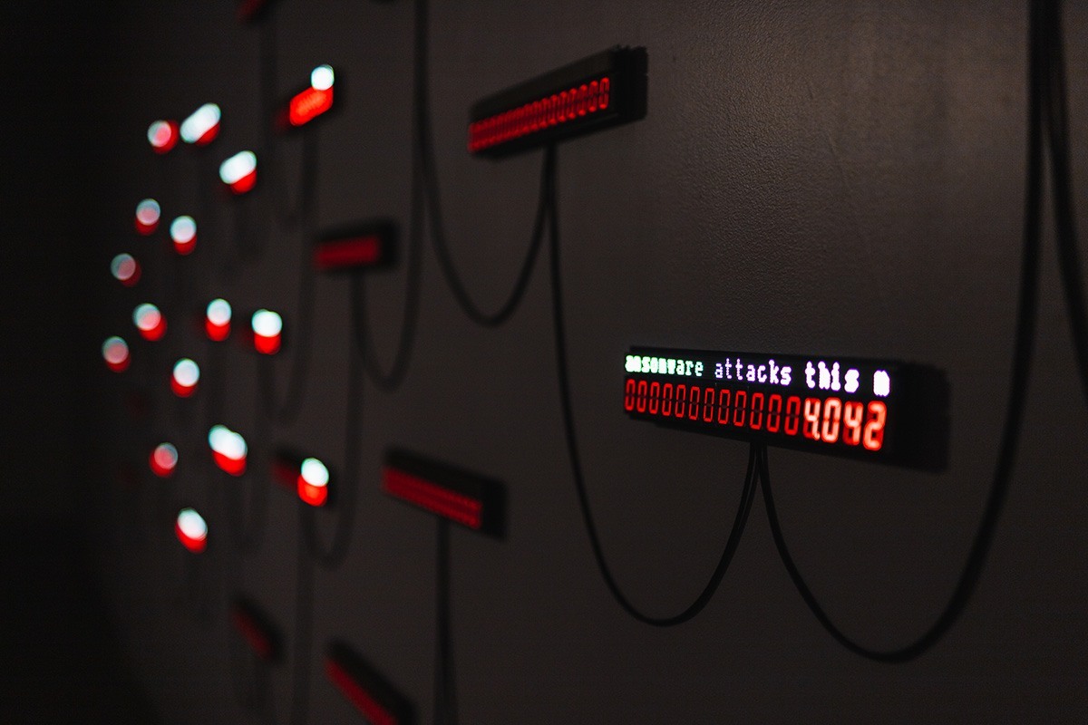 a closeup of a small LED panel hanging on a wall. the panel says '...ransomware attacks this... 4042'