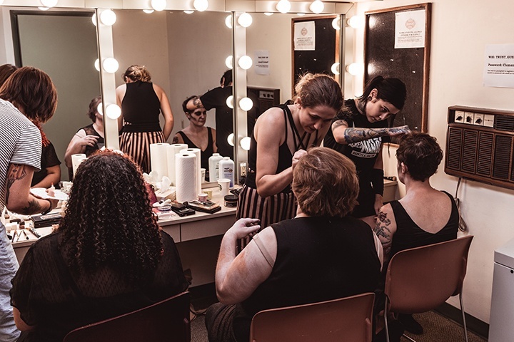 members of the makeup team turn actors into zombies