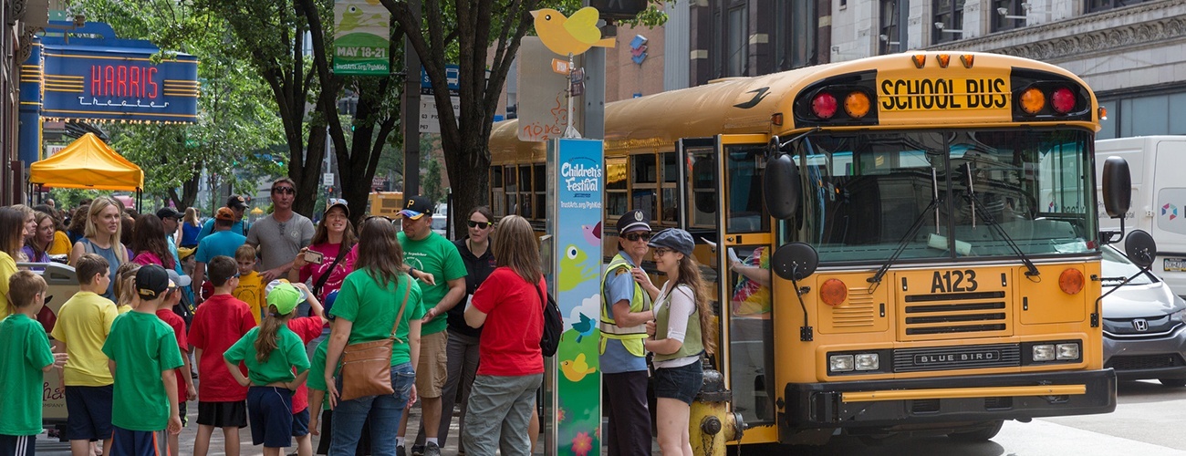 a school bus, kids walking down a street, and sign