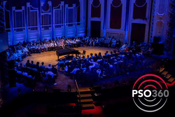 PSO360 concert with audience seated on stage around a grand piano at Heinz Hall