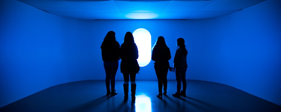 four people stand in front of an exhibit at Wood Street Galleries