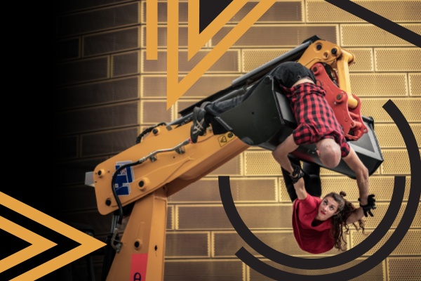 two dancers dangle from a JCB construction vehicle arm